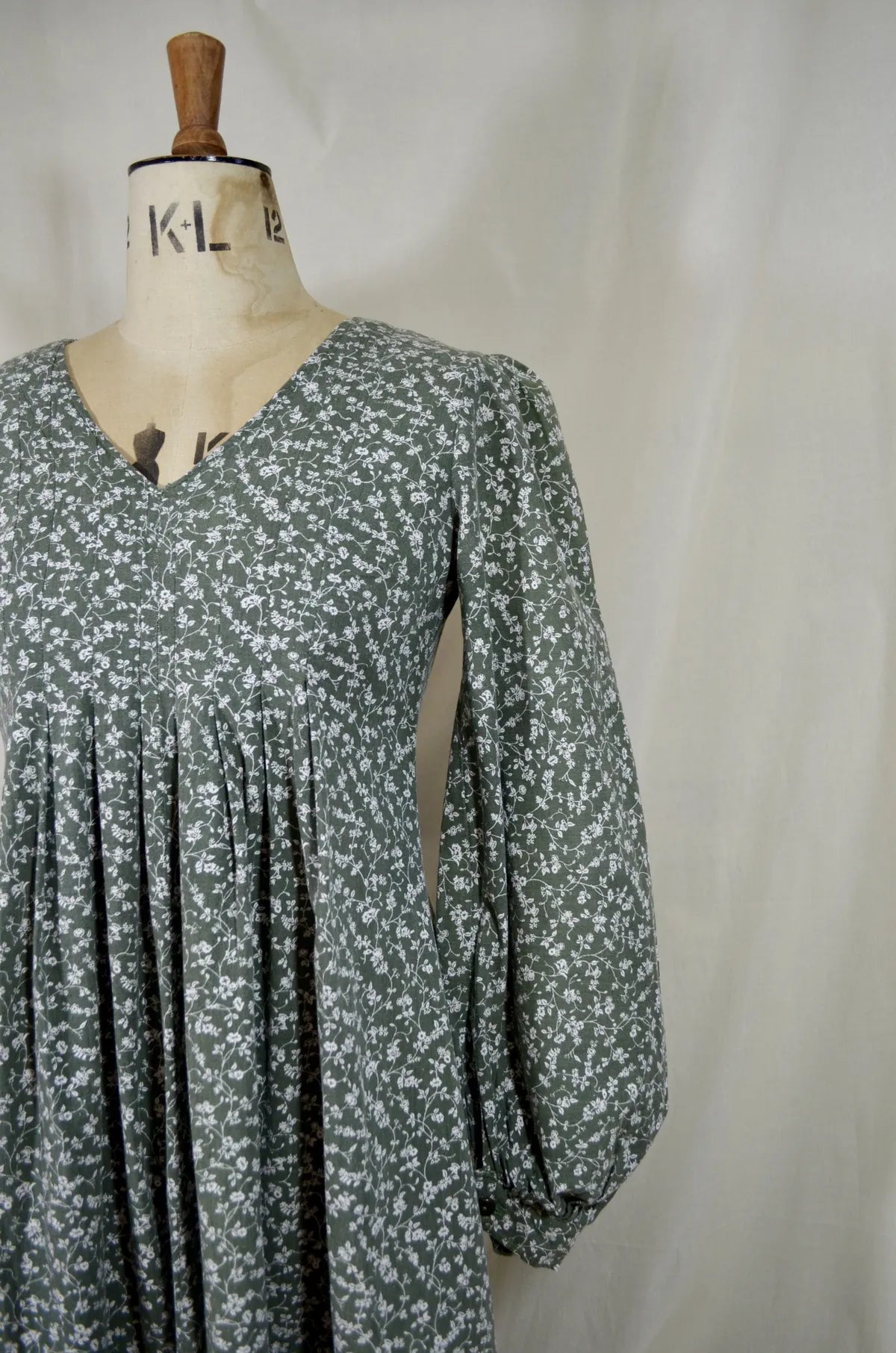 Floral dress on a mannequin against a plain background