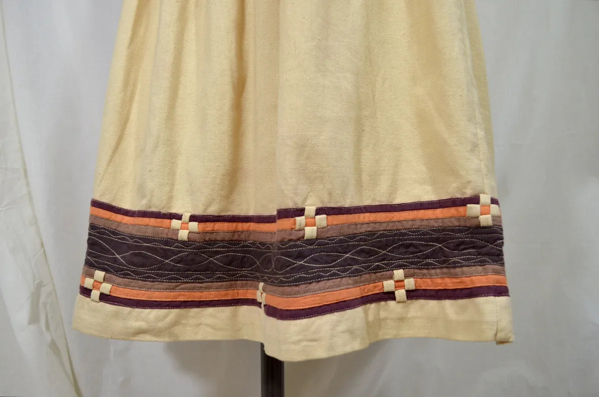 Vintage Indian thick cotton yellow dress with patchwork detail on plain background