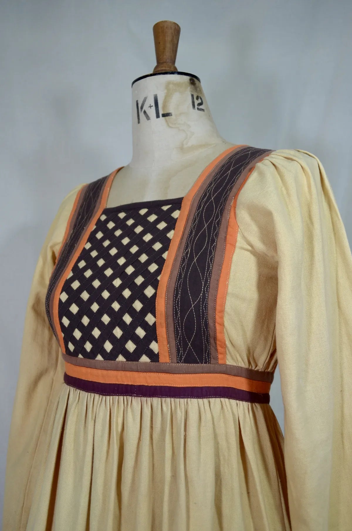 Vintage Indian thick cotton yellow dress with patchwork detail on plain background