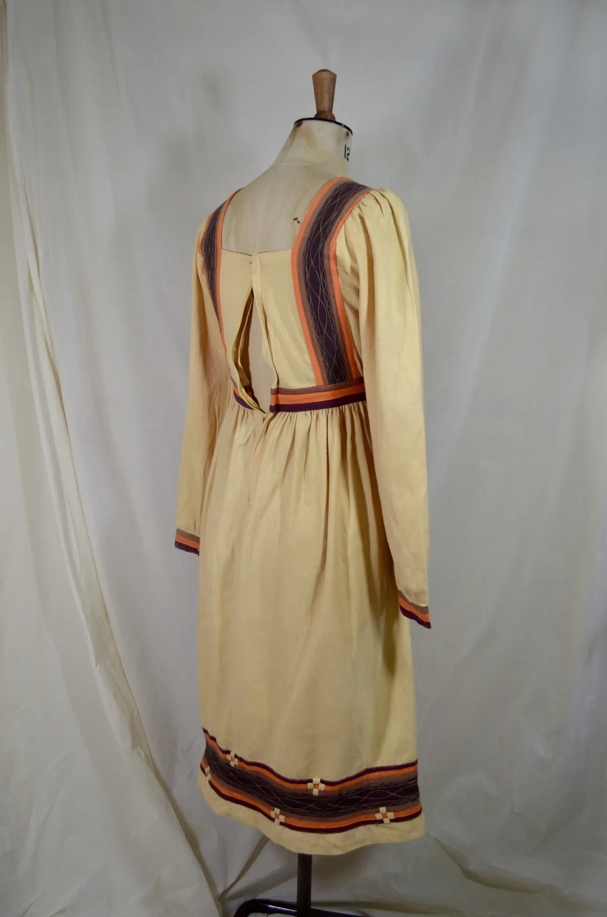 Vintage Indian thick cotton yellow dress with patchwork detail on plain background