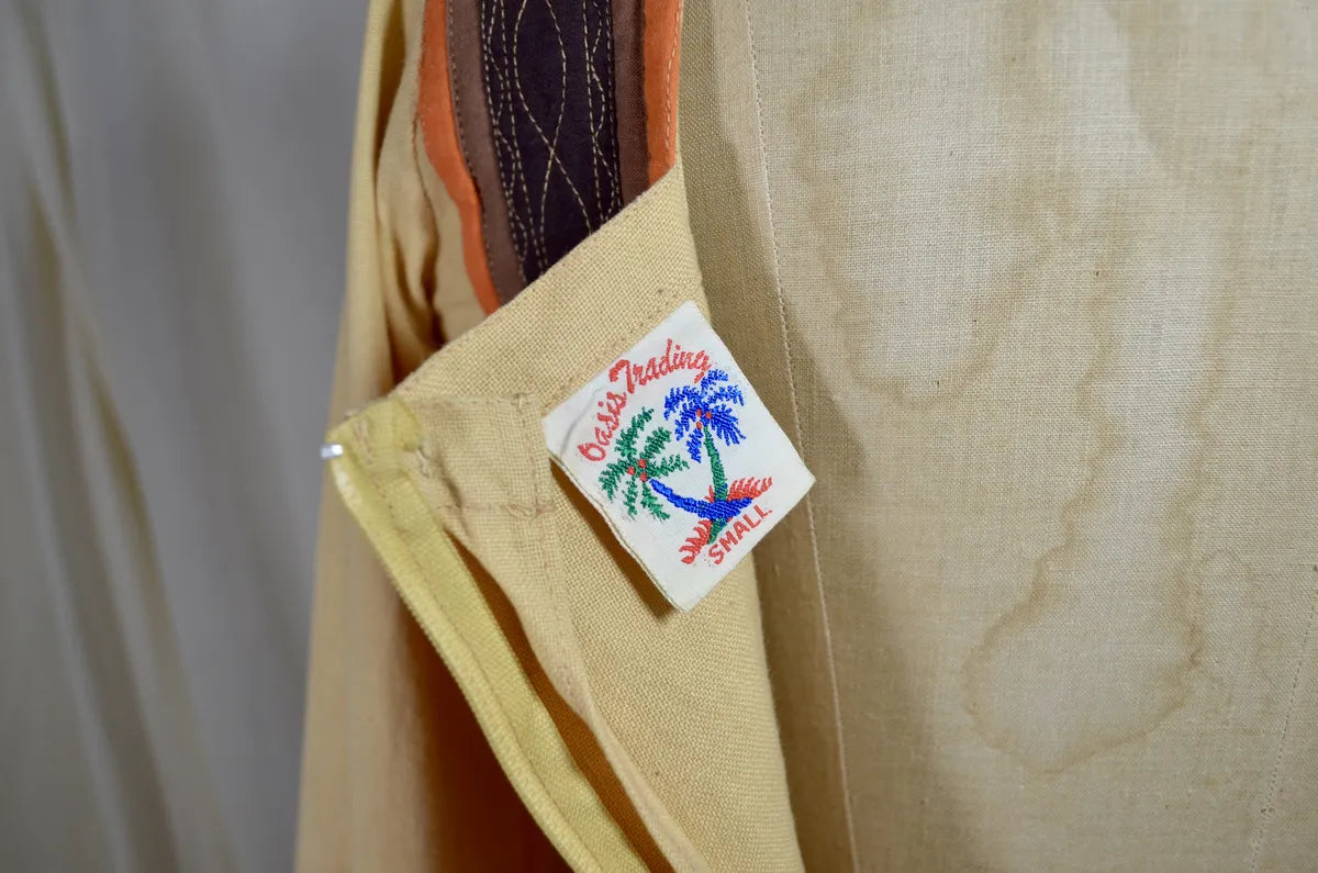 Vintage Indian thick cotton yellow dress with patchwork detail on plain background
