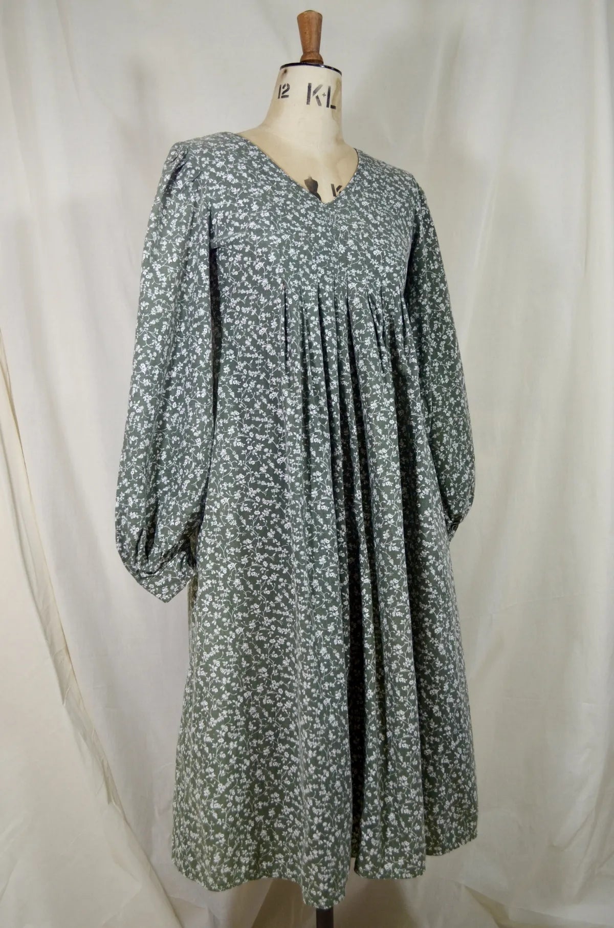 green Floral dress on a mannequin against a white background