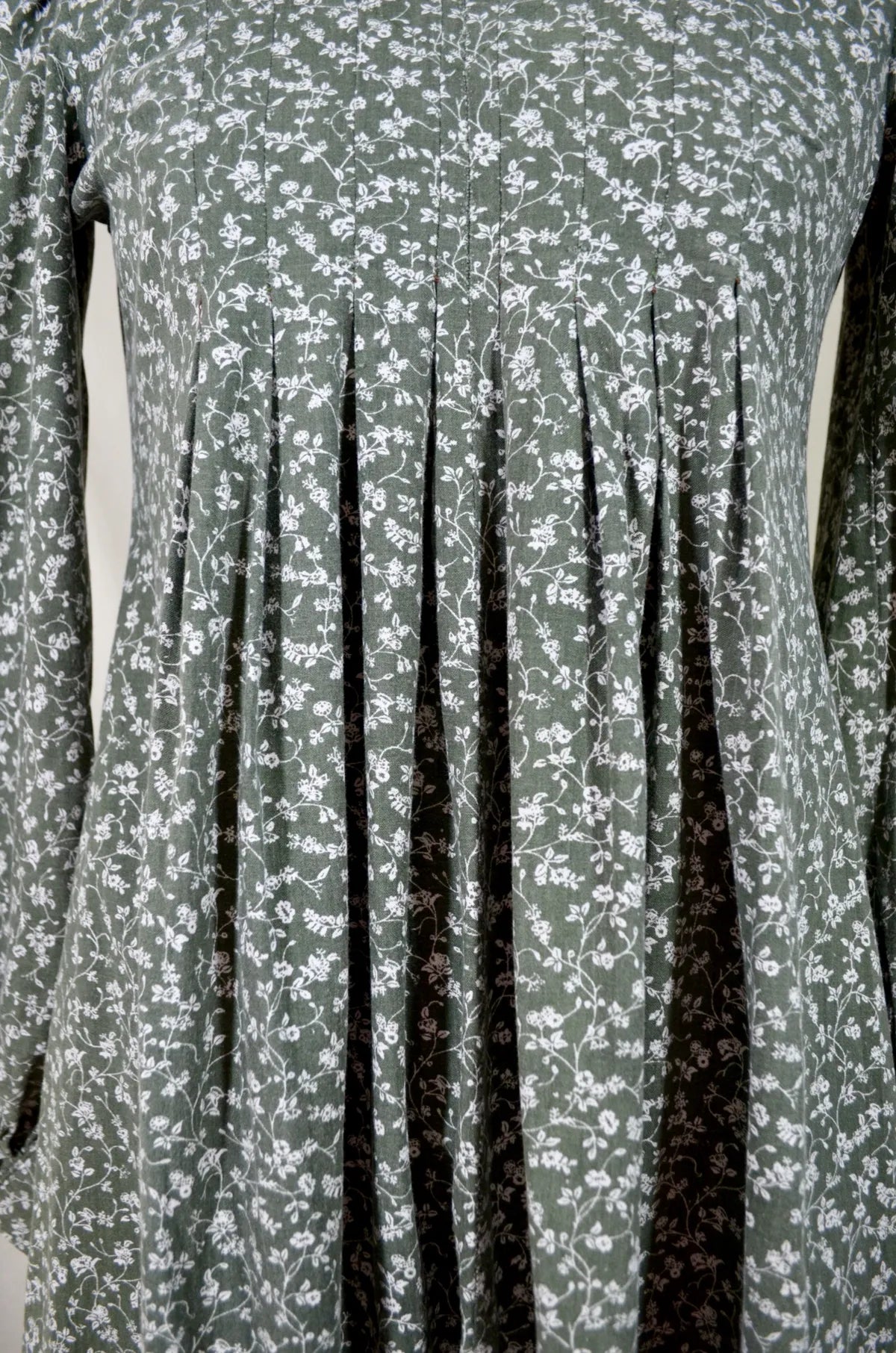 Green Floral patterned dress with pleated front on a plain background