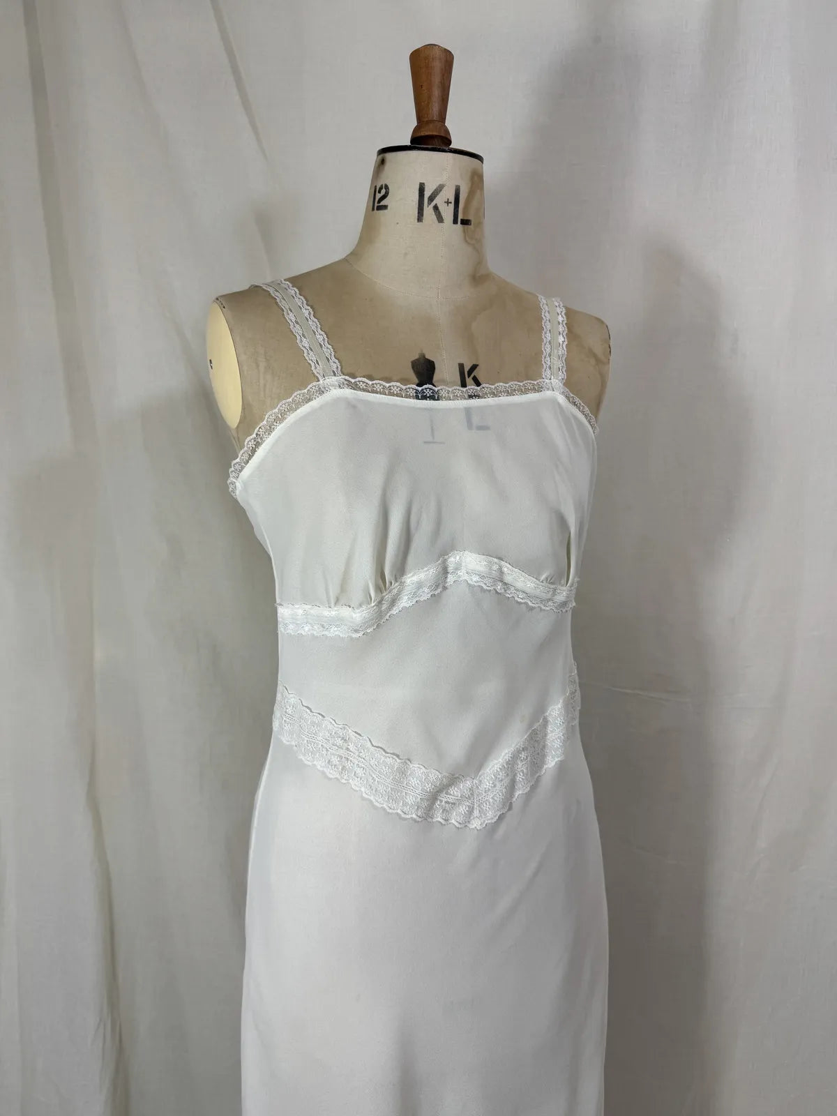 White nightgown on a mannequin against a plain background