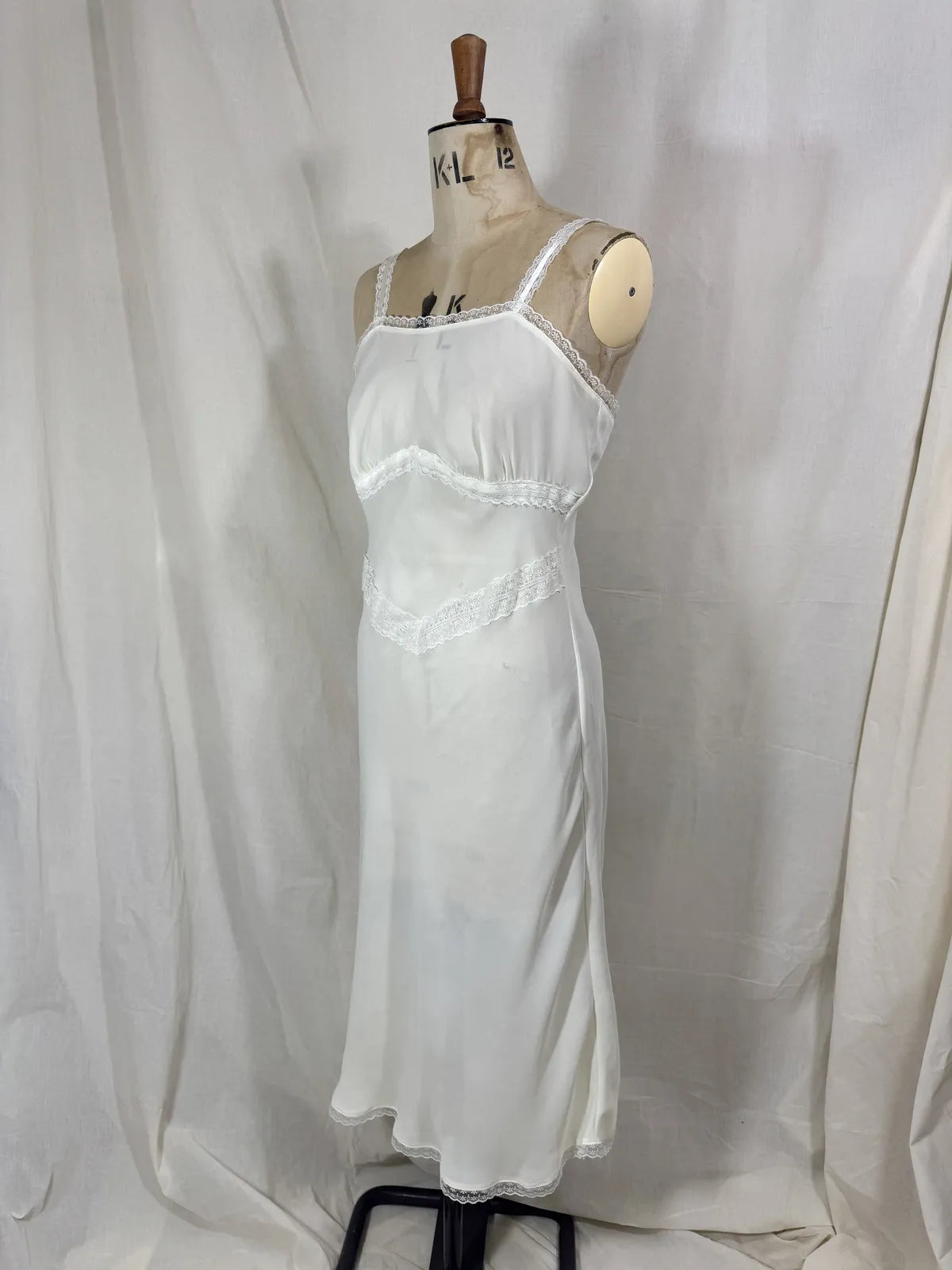 White nightgown on a mannequin against a plain background