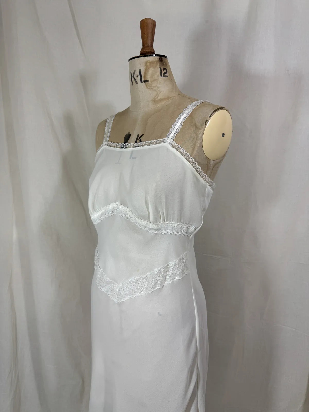 White nightgown on a mannequin against a plain background
