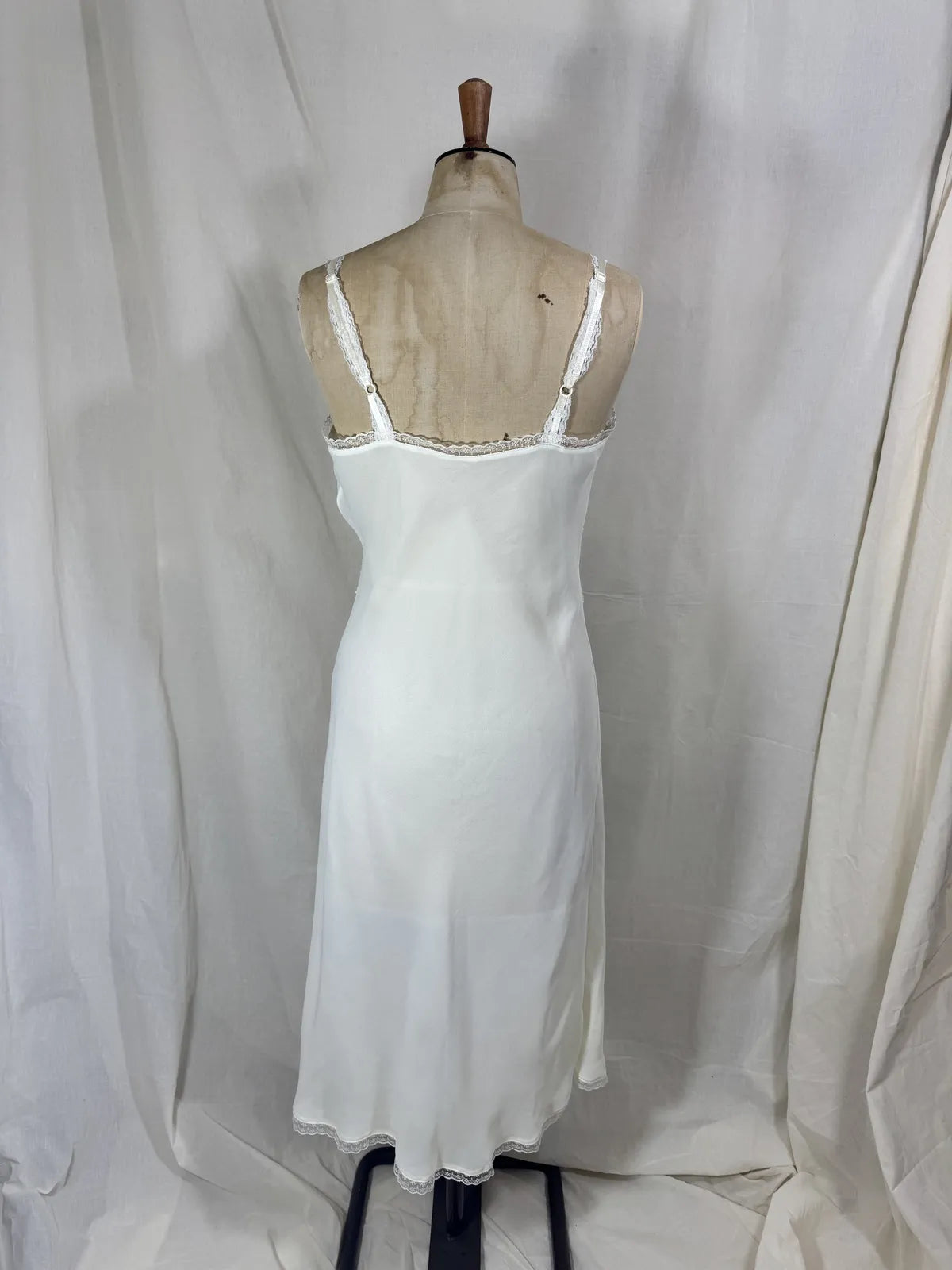 White nightgown on a mannequin against a plain background
