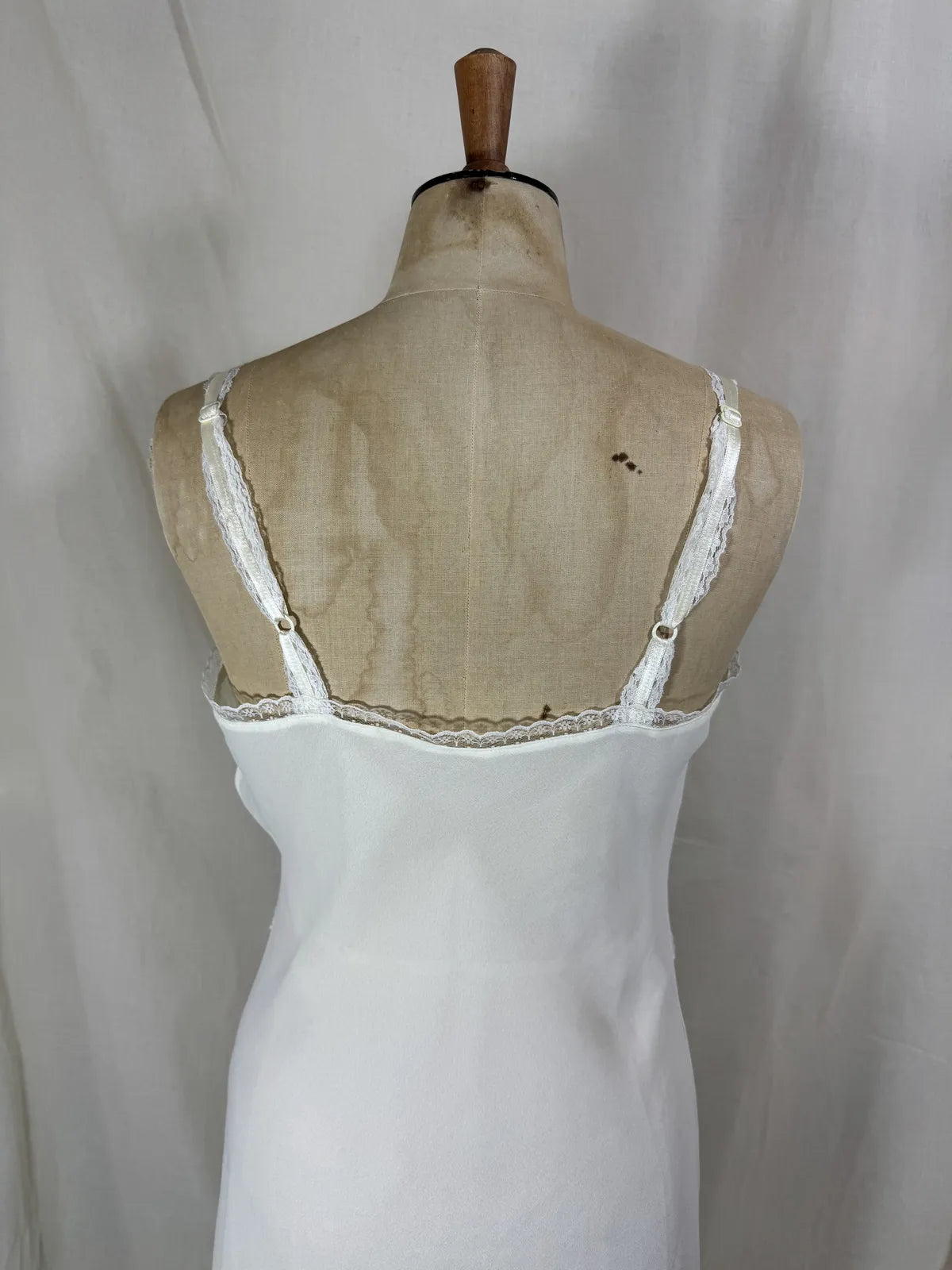 White nightgown on a mannequin against a plain background