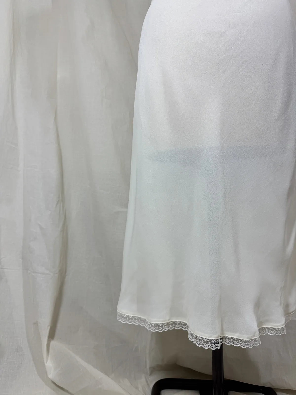 White nightgown on a mannequin against a plain background