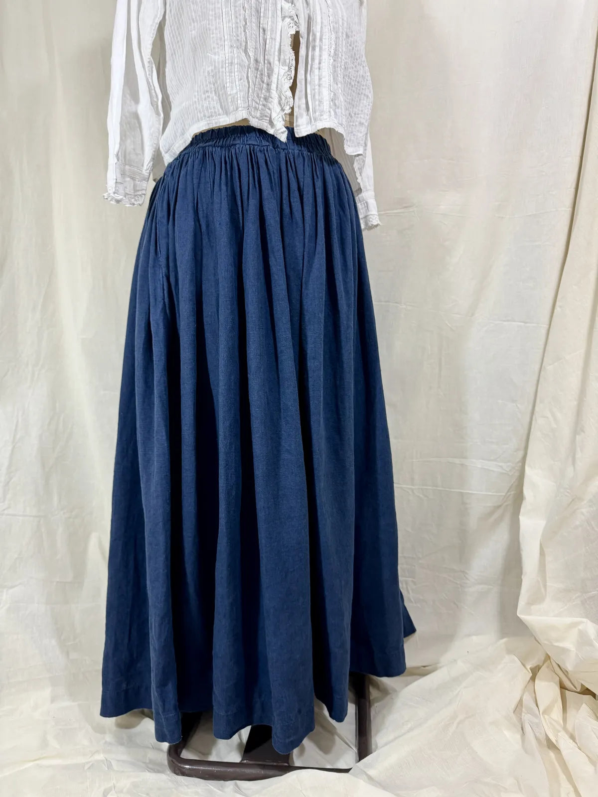 Blue skirt and white blouse on a neutral background