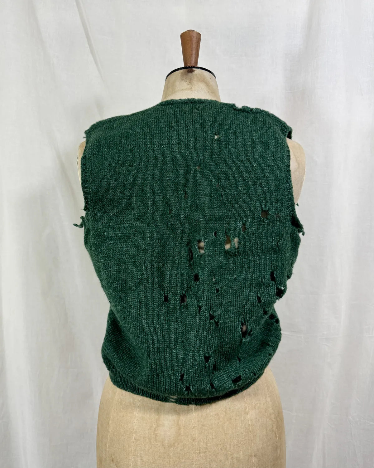1920s green knitted vest on a mannequin against a white background