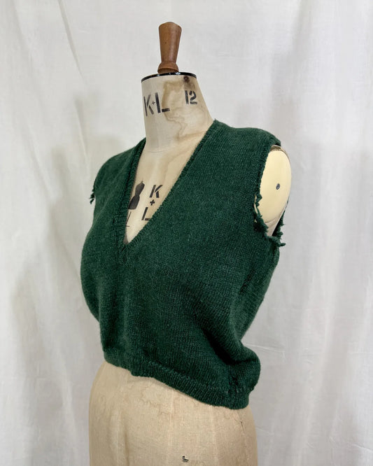 1920s green knitted vest on a mannequin against a white background