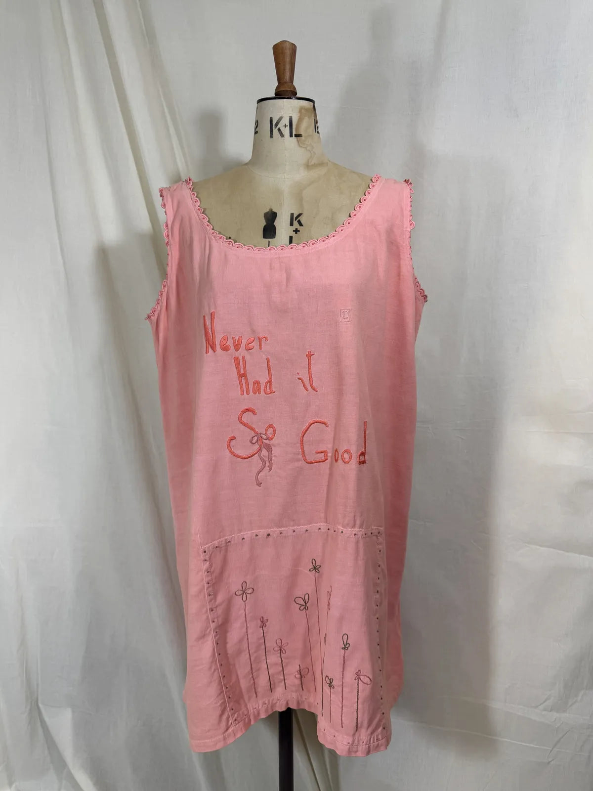 Victorian pink linen embroidered dress against white background