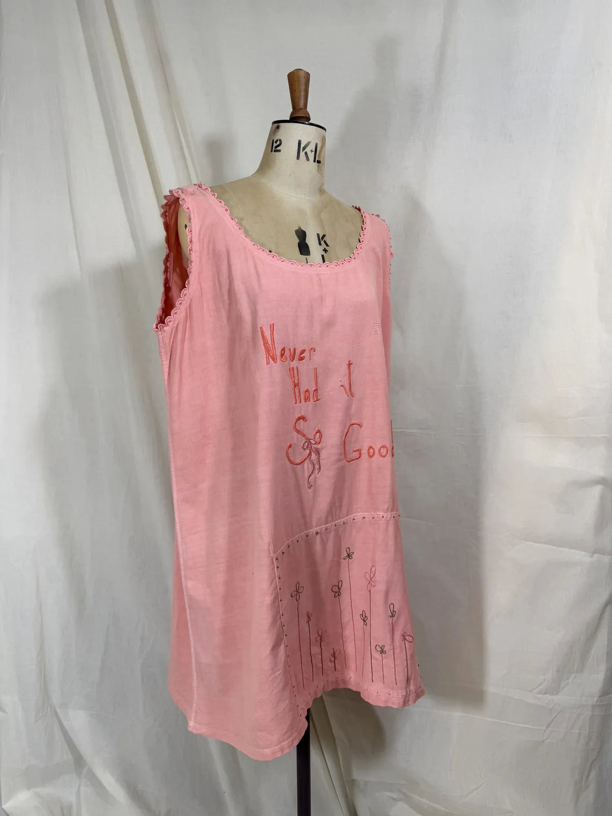 Victorian pink linen embroidered dress against white background