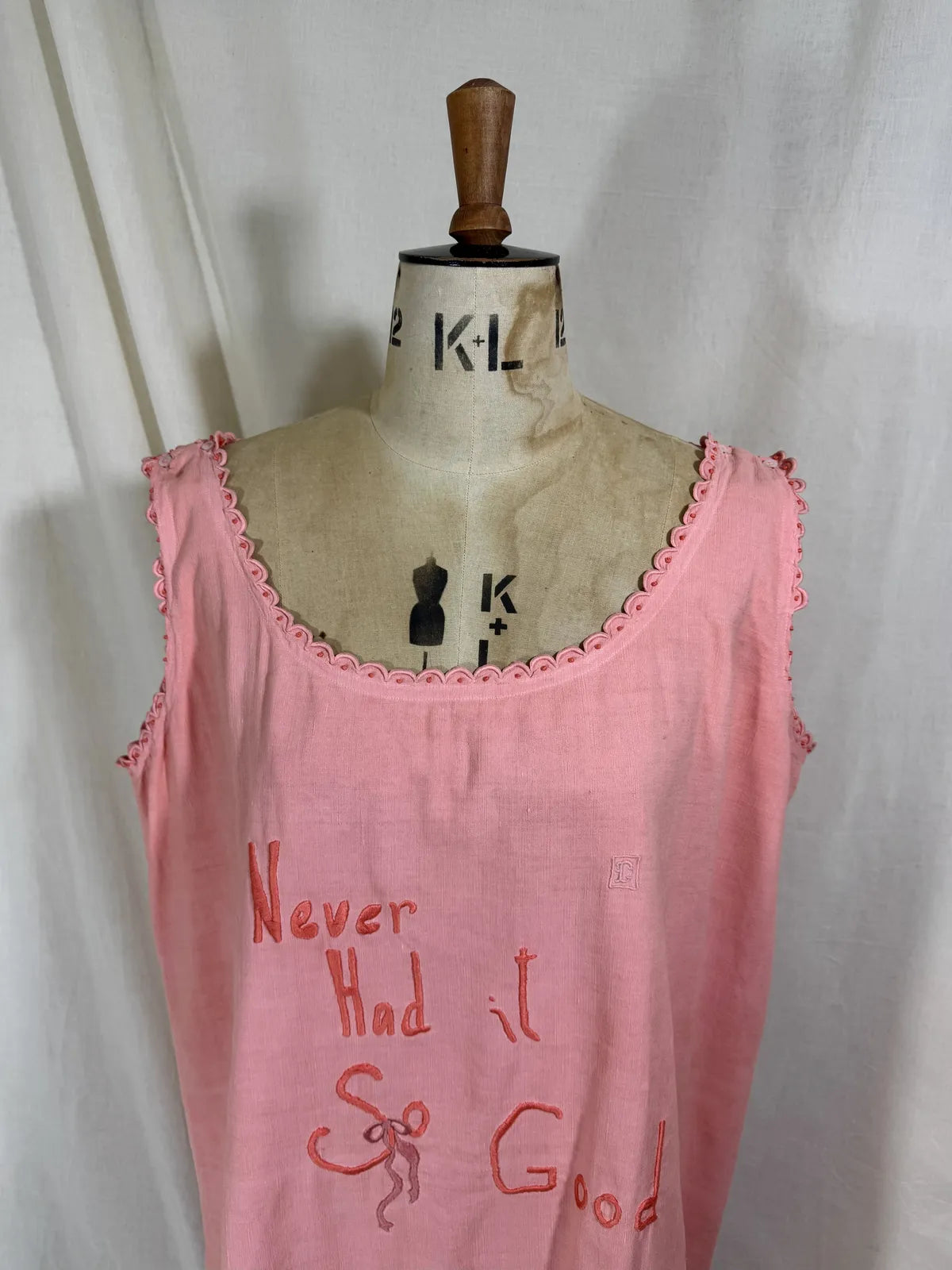 Victorian pink linen embroidered dress against white background