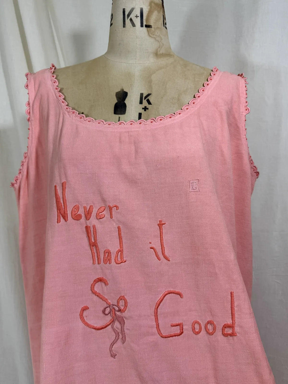 Victorian pink linen embroidered dress against white background