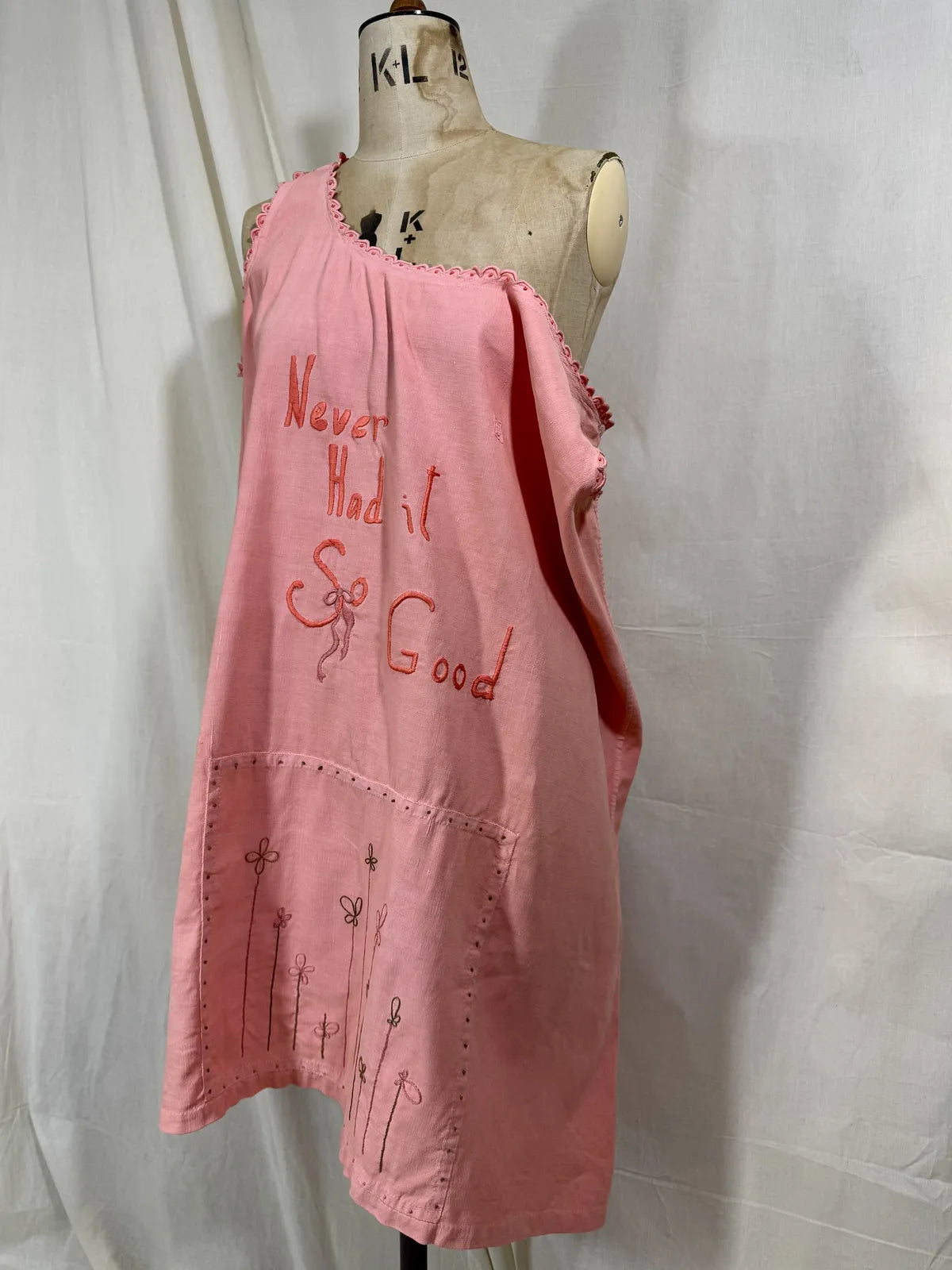 Victorian pink linen embroidered dress against white background