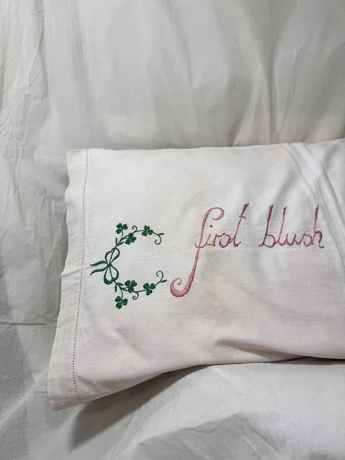 Embroidered pillow with decorative text on a white background
