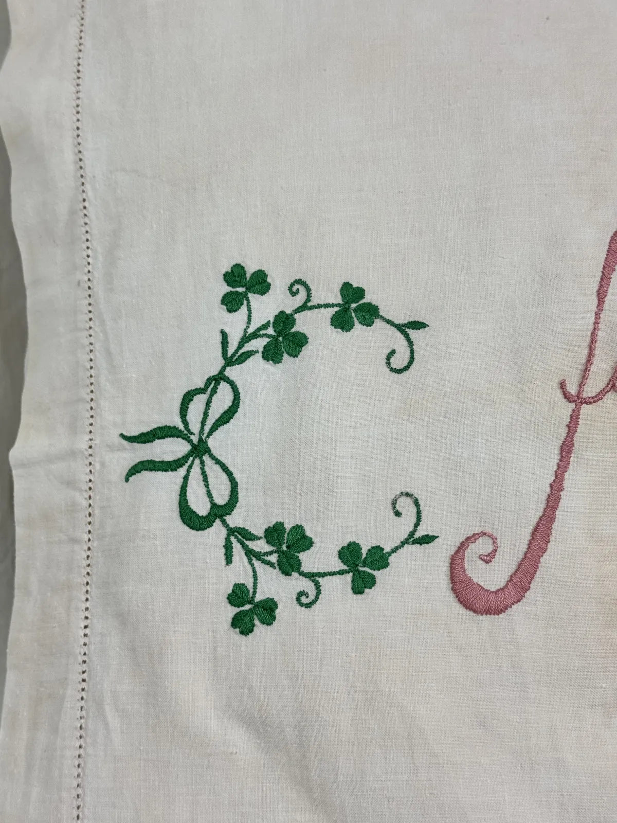 Embroidered pillow with decorative text on a white background