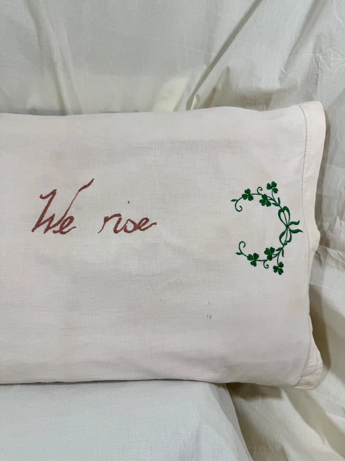 Pillow with embroidered text and design on a white background
