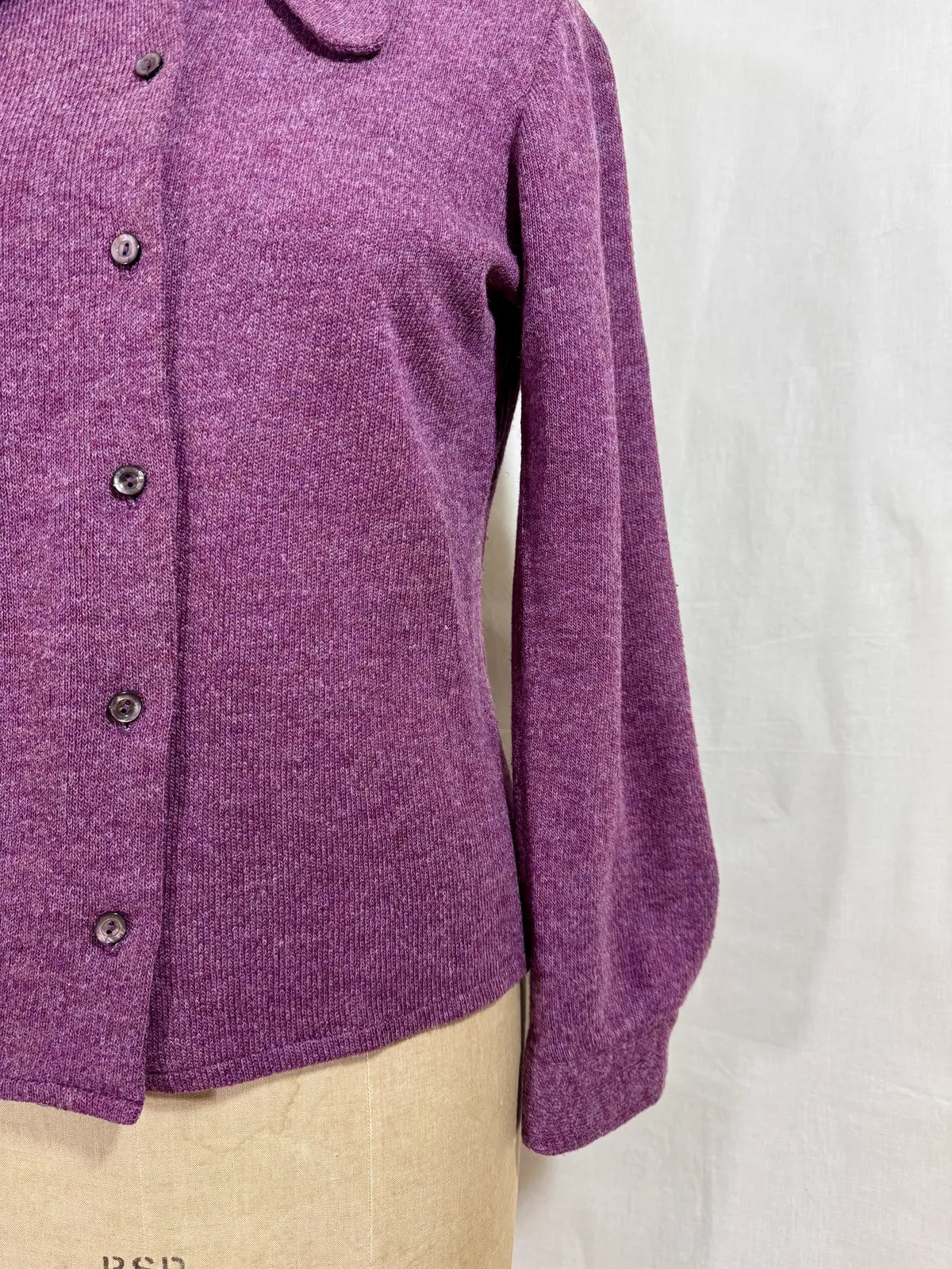 Purple wool cardigan on a mannequin with a white background