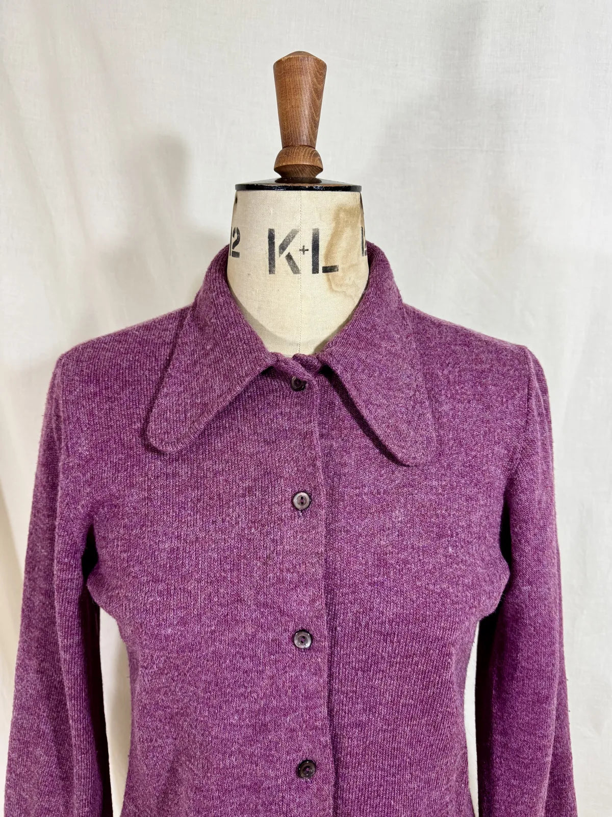 Purple wool cardigan on a mannequin with a white background