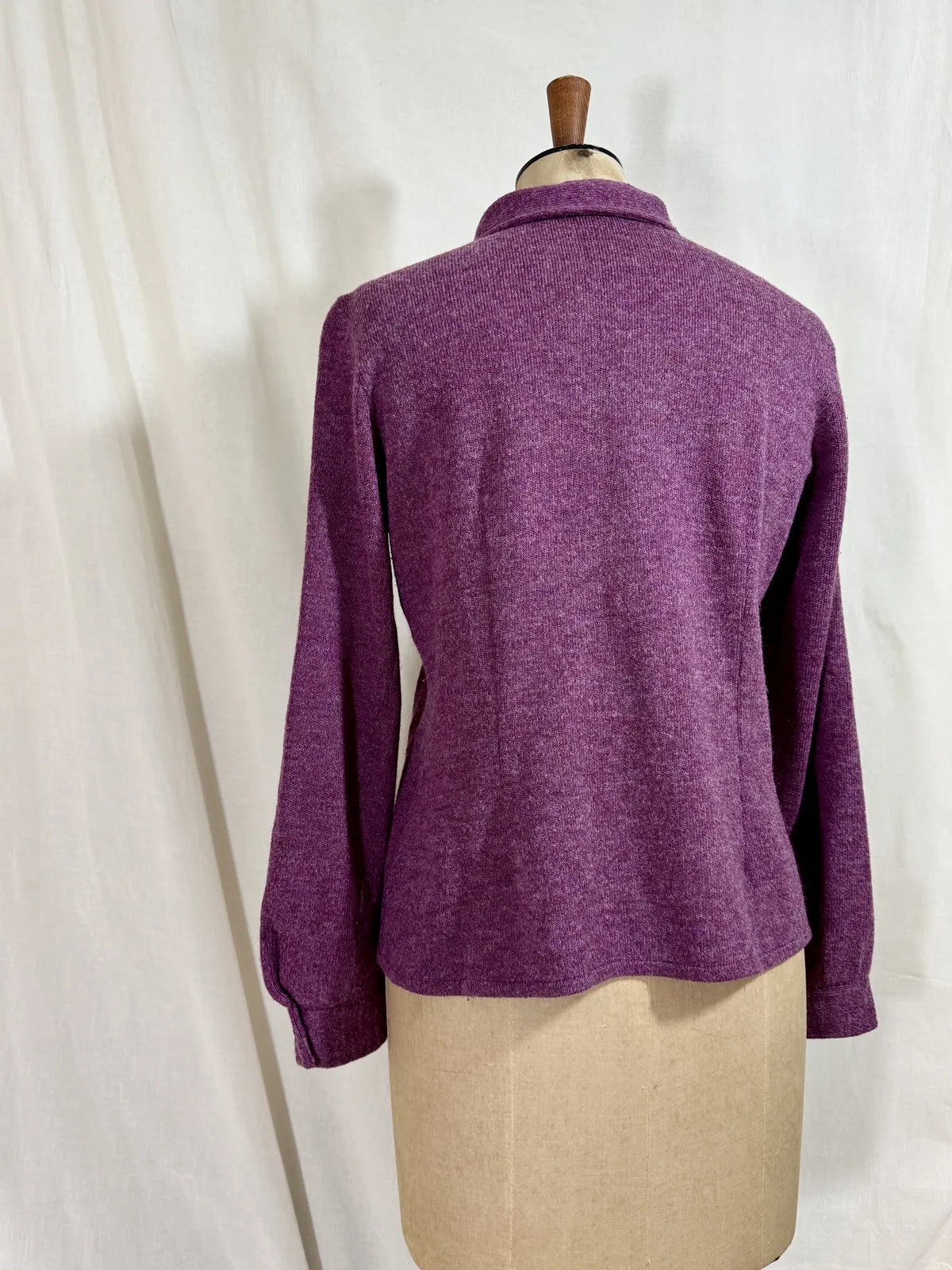 Purple wool cardigan on a mannequin with a white background