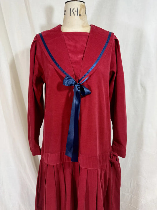 Red dress with a blue ribbon on a mannequin against a white background