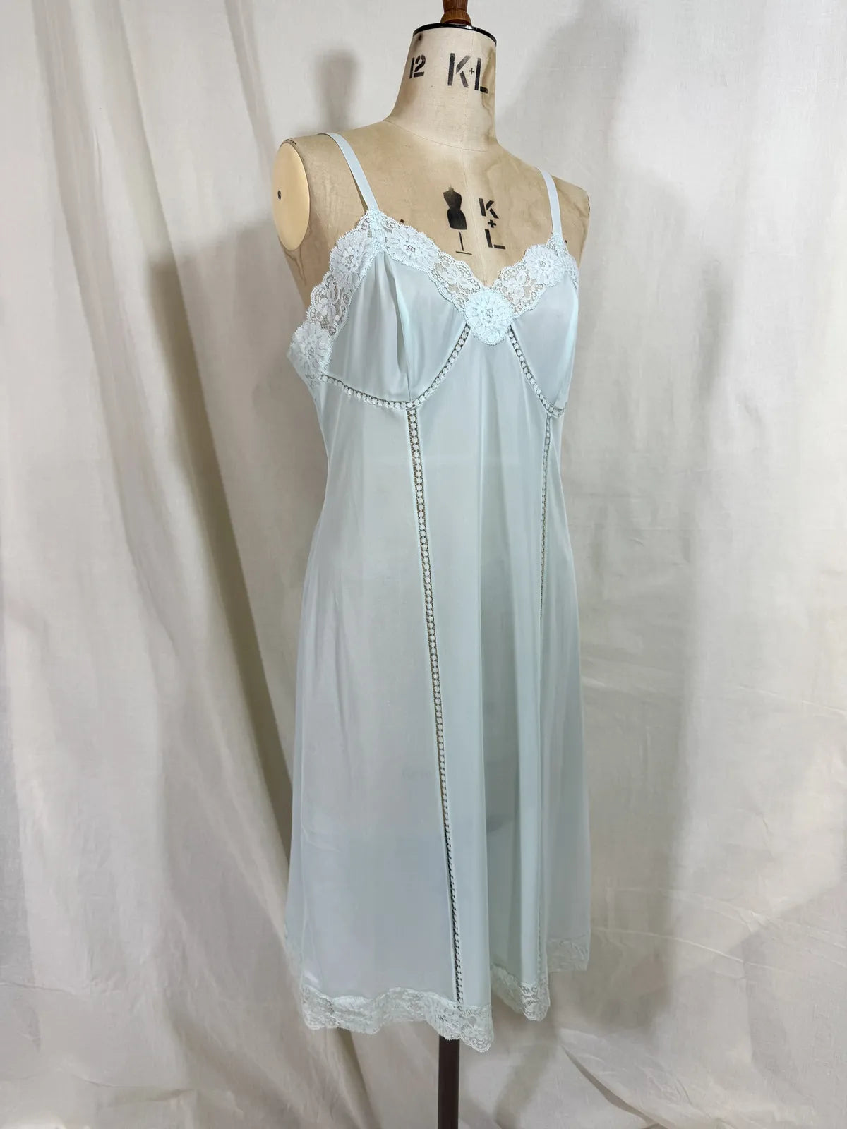 Light blue slip dress on a mannequin against a white background