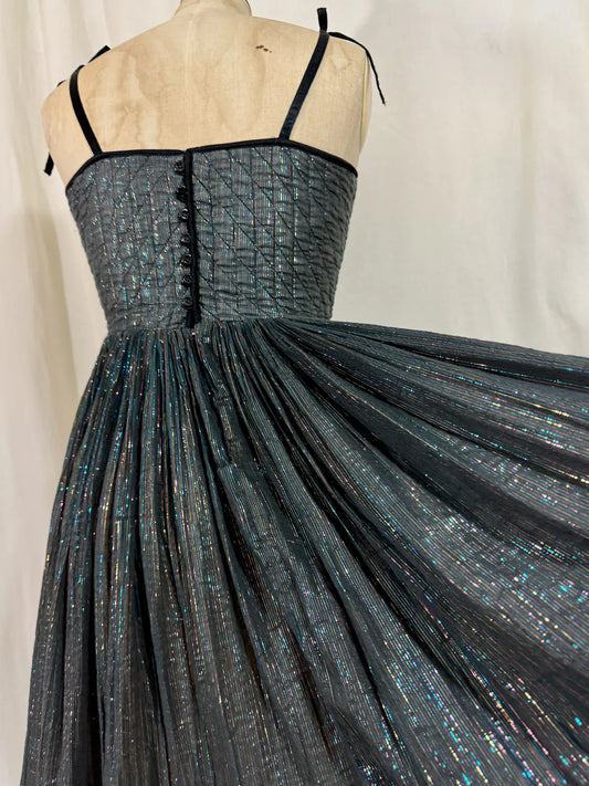 Black metallic cotton gauze dress on a mannequin against a white curtain background