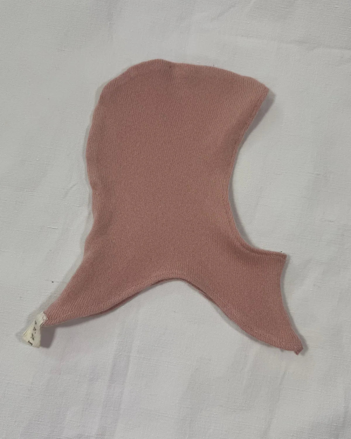 Pink cashmere hood for infant on a white background