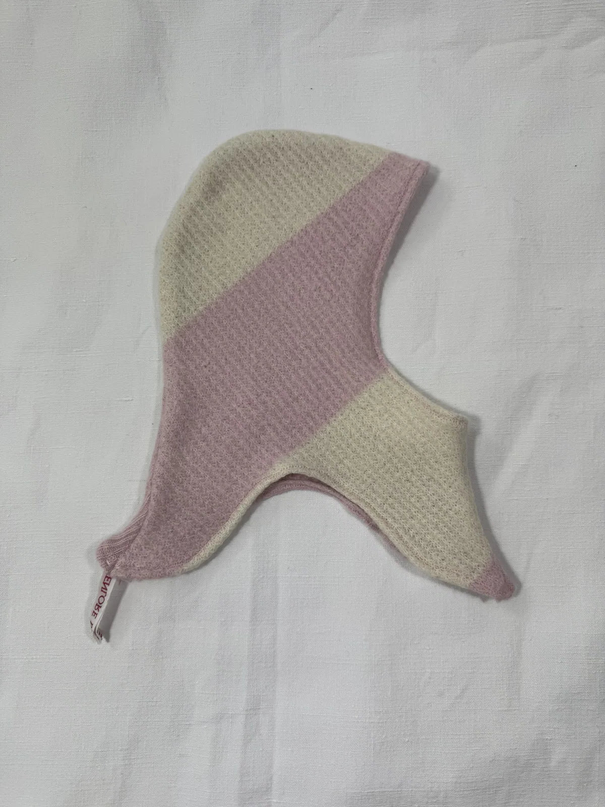 Pink striped cashmere hood for infant on a white background