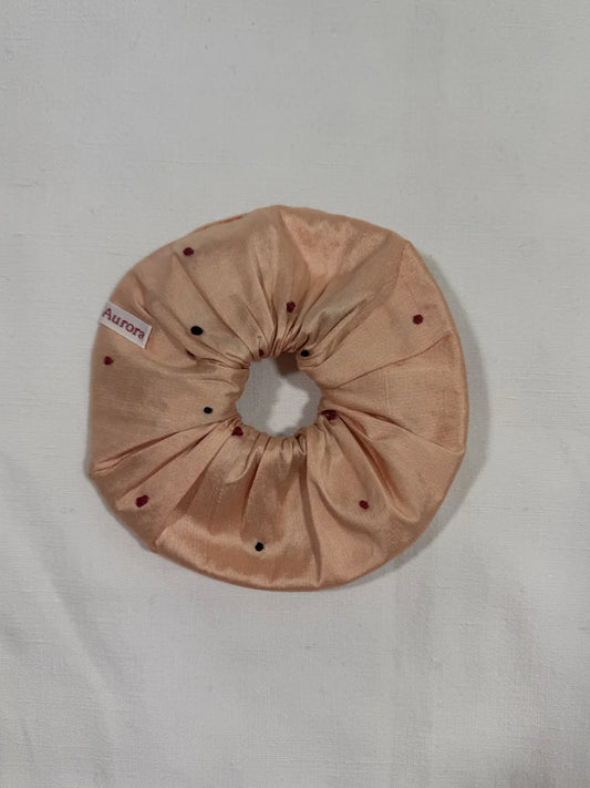 Apricot pink Dupion silk scrunchie with hand embroidery on a white background