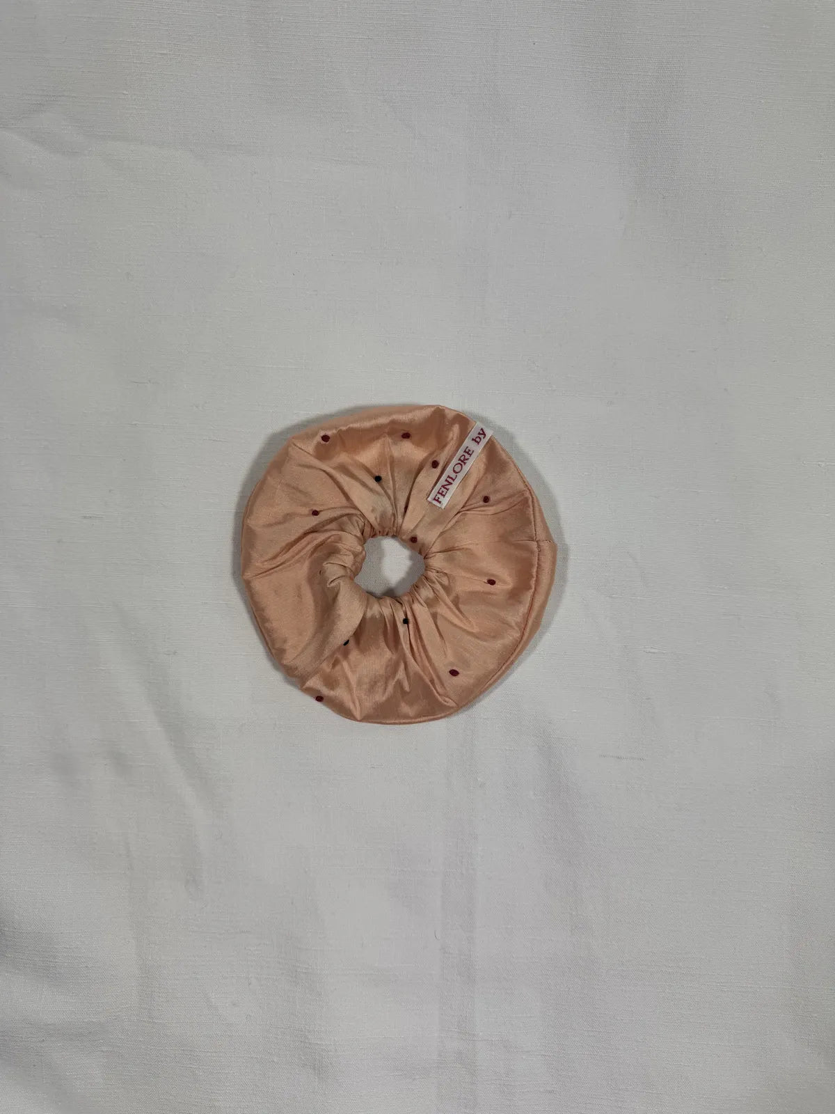 Apricot pink Dupion silk scrunchie with hand embroidery on a white background