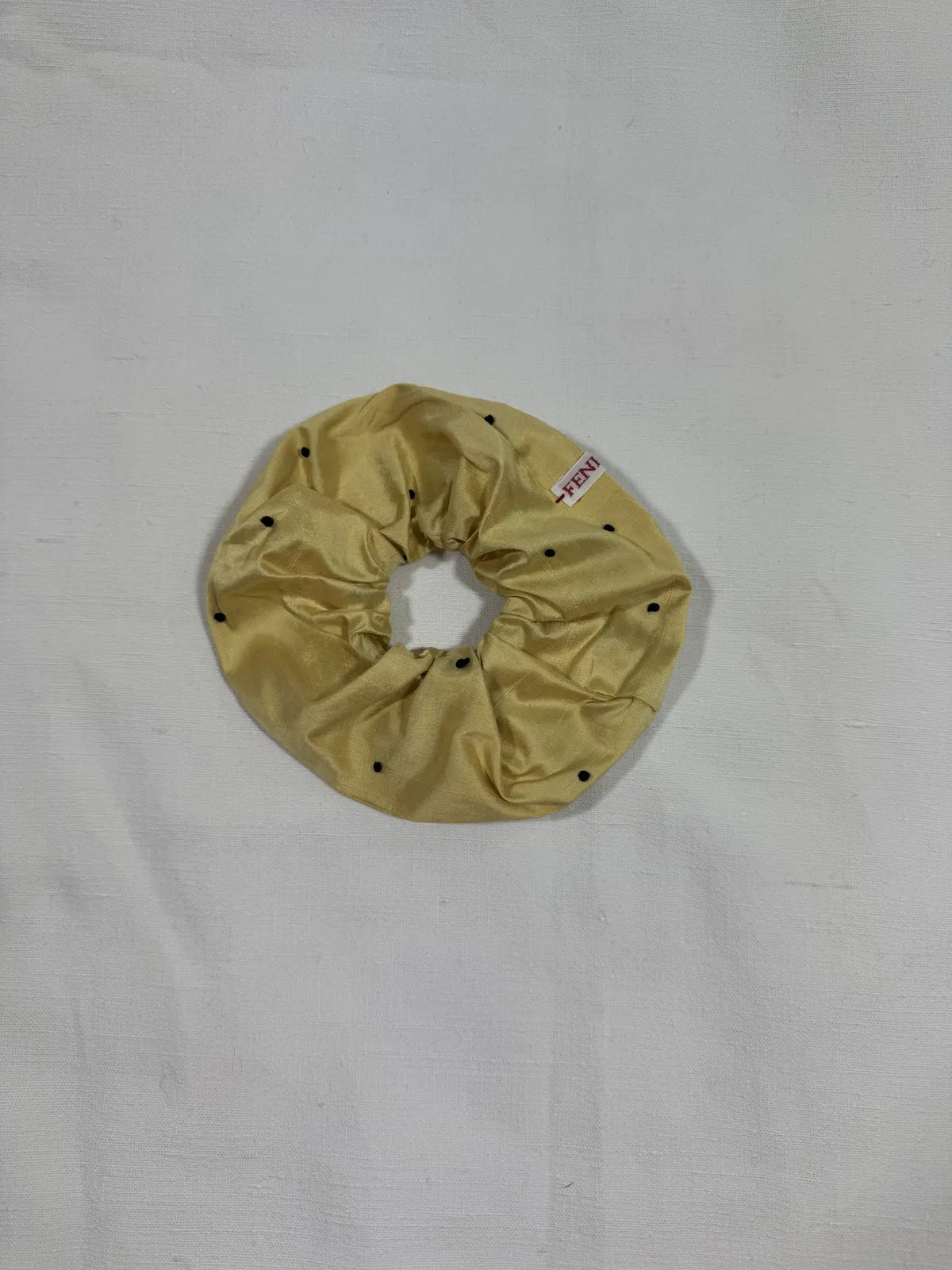 yellow silk scrunchie with hand embroidery against a white backdrop