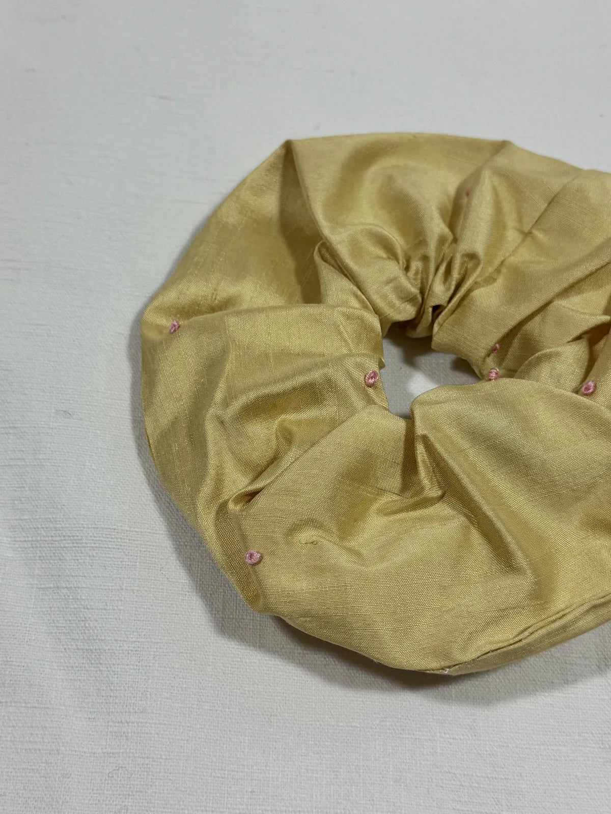 yellow silk scrunchie with hand embroidery against a white backdrop