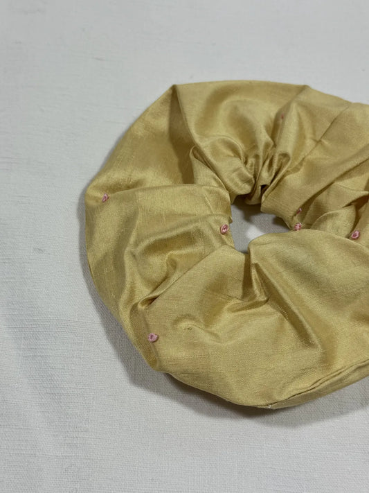 yellow silk scrunchie with hand embroidery against a white backdrop
