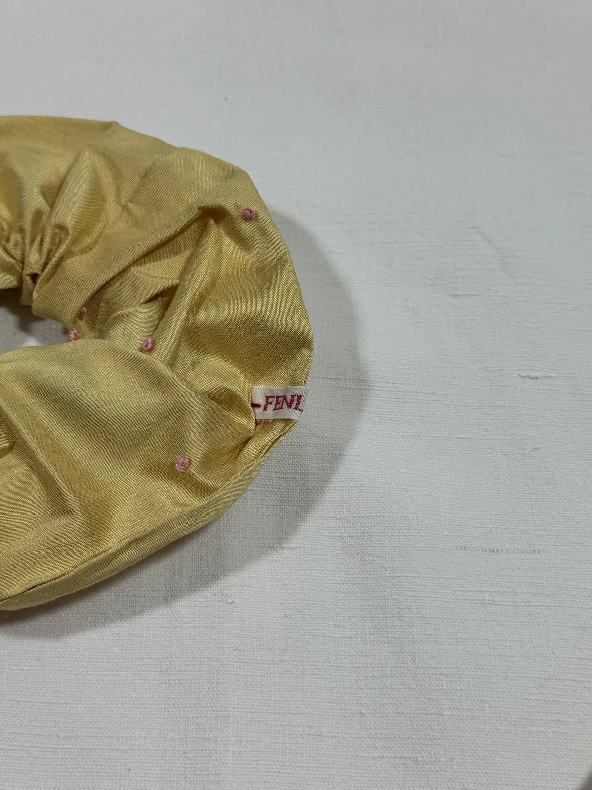 yellow silk scrunchie with hand embroidery against a white backdrop