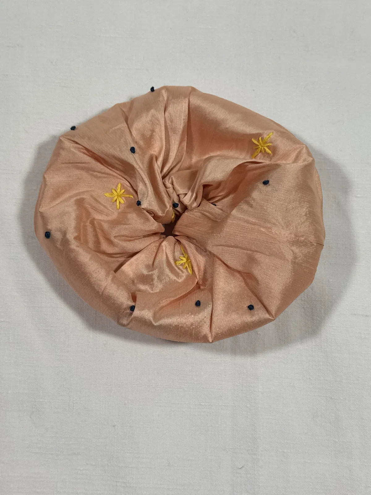 Apricot pink large scrunchie with hand embroidery against white background