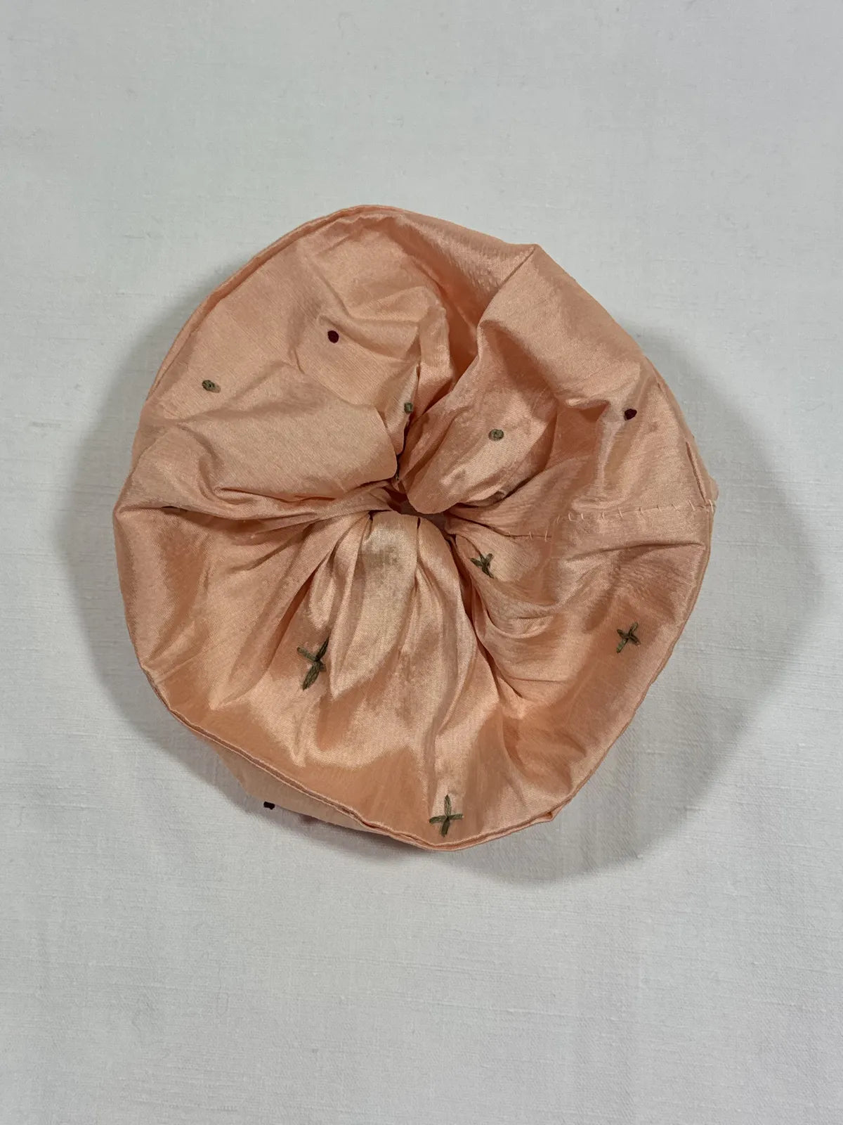 Apricot pink large scrunchie with hand embroidery against white background