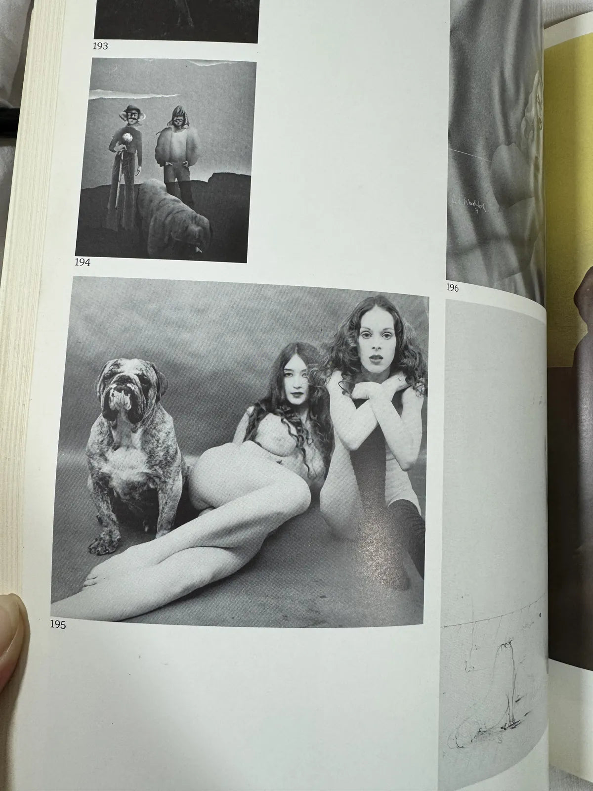 Open book showing black and white photograph of two people and a dog on a page.