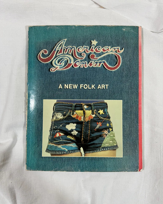 Book titled 'American Denim: A New Folk Art' on a white background