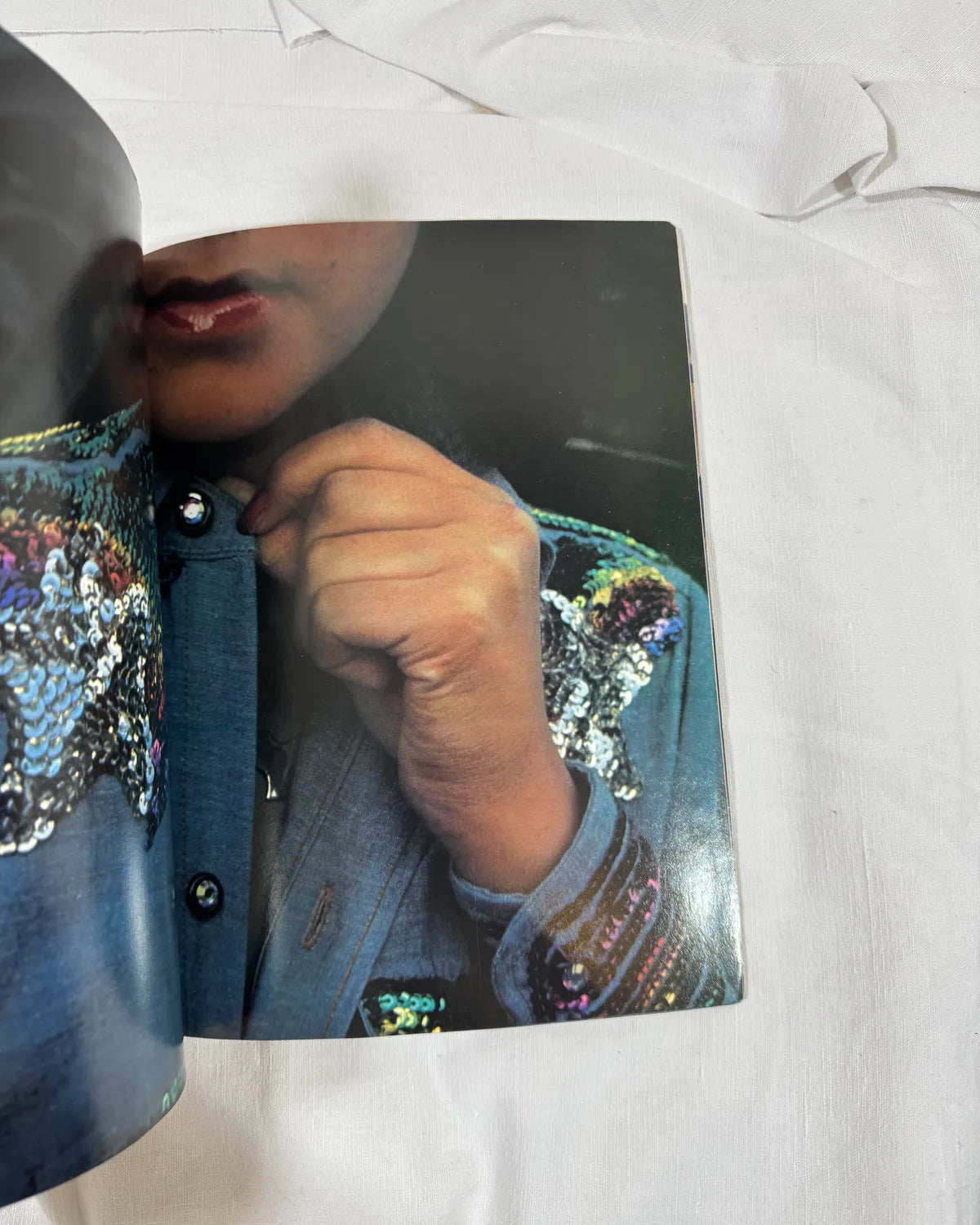 Close-up of a person wearing a sequined jacket on a white background