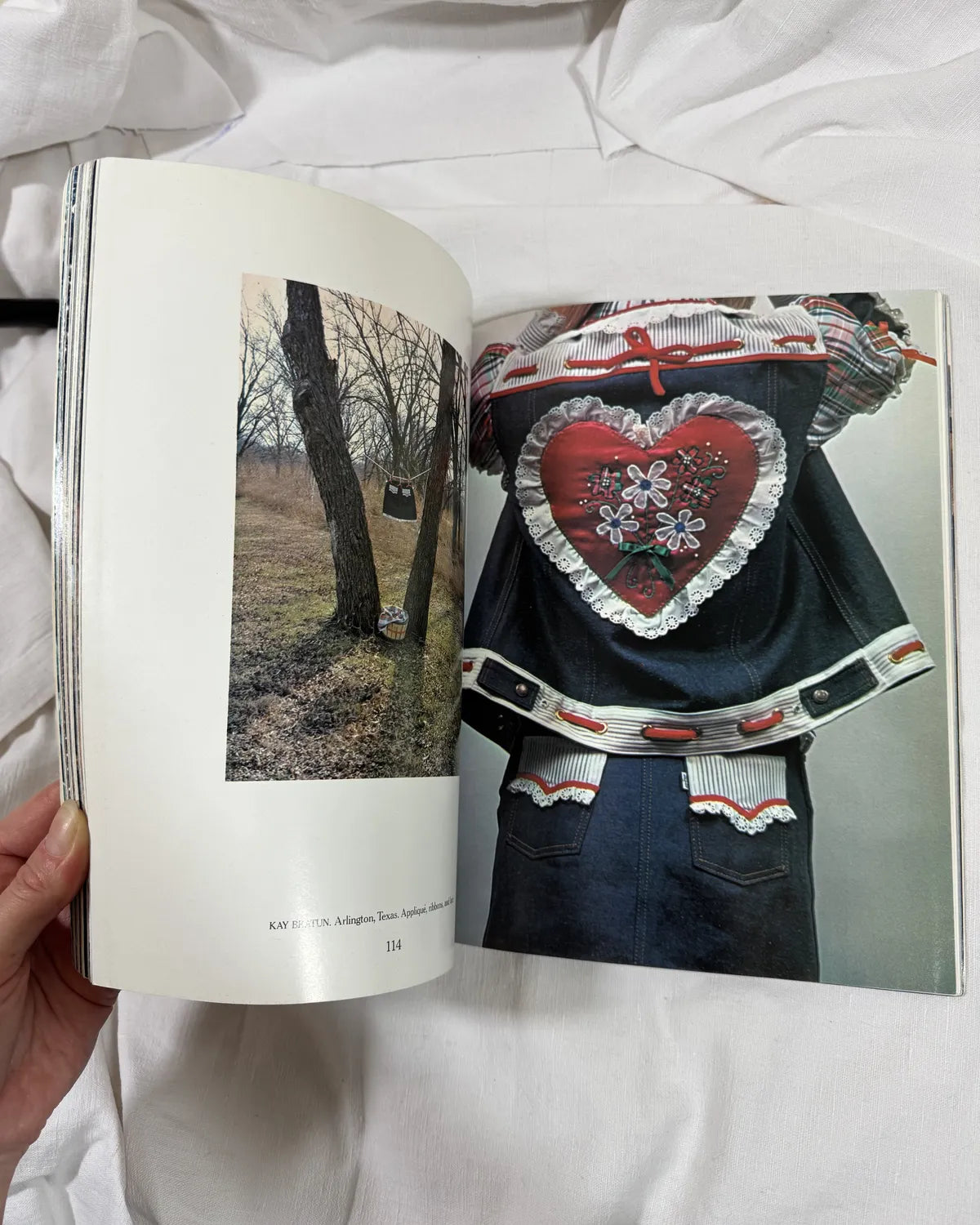 Open book showing a person wearing a sweater with a heart design.