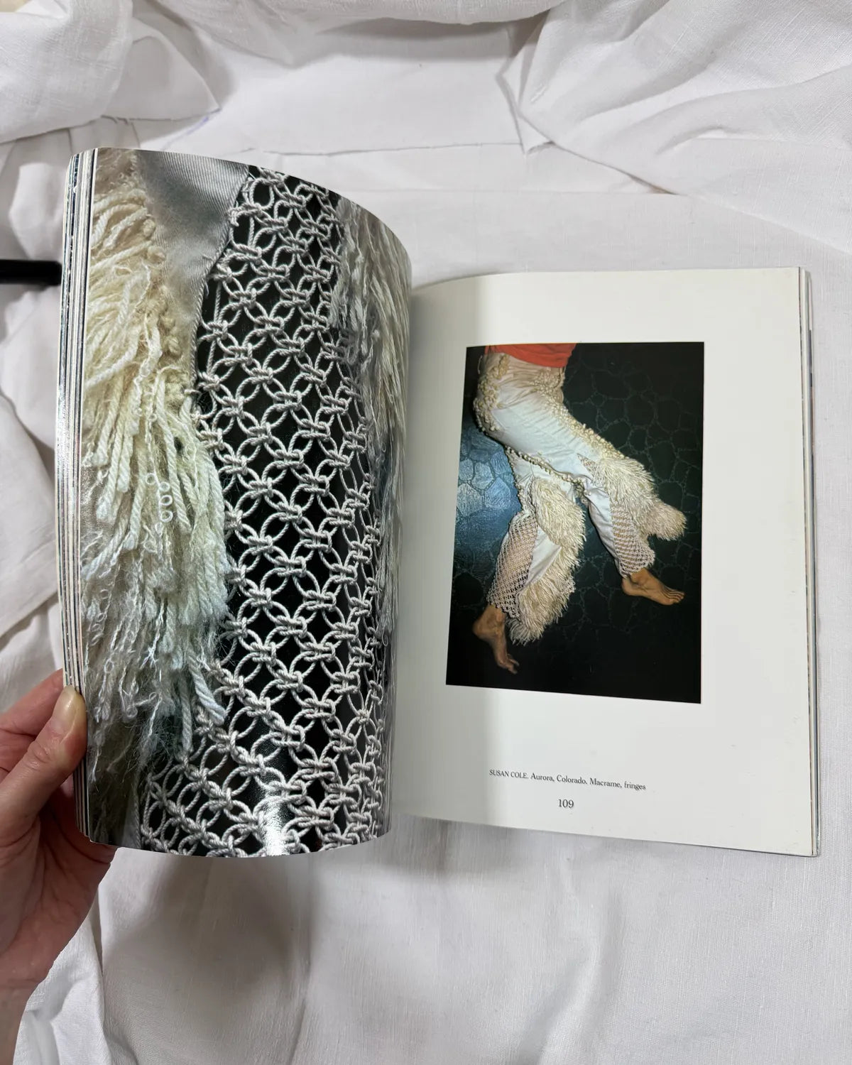Open book showing a patterned fabric and a photo of legs in fishnet stockings.